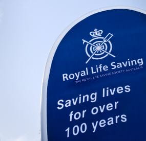 A flag stating Royal Life Saving, Saving Lives for Over 100 Years.