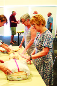 Seniors practising CPR on a manikin