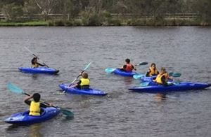 children in Kayaks paddling on the Swan River