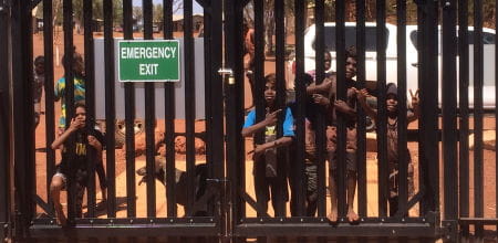 Children lining up along the gate at Balgo pool waiting for opening