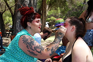 A teenager having their face painted