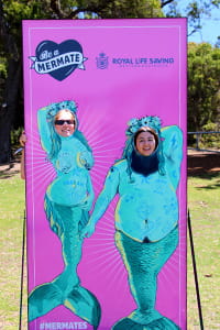 Teenagers behind a mermaid sign