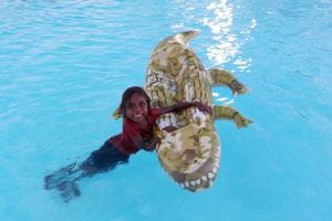 An Aboriginal child on a crocodile pool float