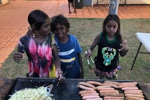 Bidyadanga children cooking sausages on a BBQ