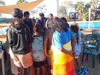 family and friends gathering by the Yandeyarra pool to sing happy birthday to Elijah