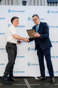 Jake Dwyer receives his Gold Star from Royal Life Saving WA President Vaughan Davies