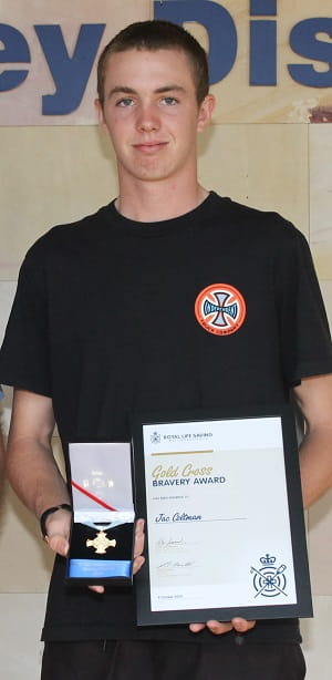 Jac Coltman holding his Gold Cross Bravery Award