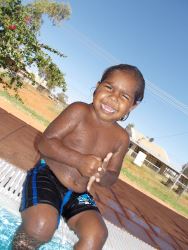 little boy sitting on the side of the pool