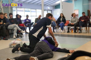 Trainer Ryan Scally demonstrating recovery position as students look on