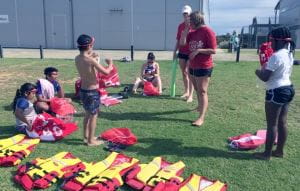 Children with their swim instructors learning about lifejackets at Champion Lakes