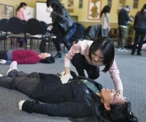 A woman practising emergency response on another woman