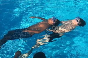 Two children practising rescue swimming in the pool