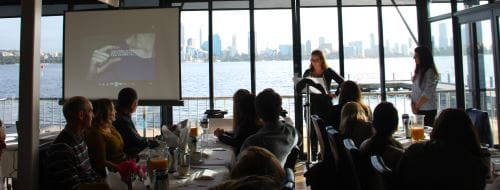 Image of community trainers sitting at table looking out on the Swan River at The Boat Shed