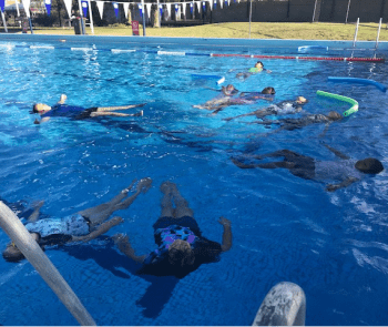 Children floating on their back in the pool at Coolgardie