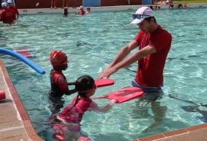 Two children with their swim instructor in the pool at Dianella