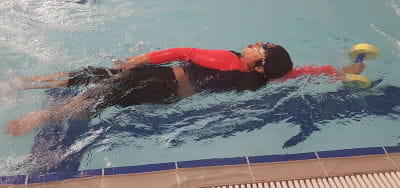 A boy swimming freestyle in a pool