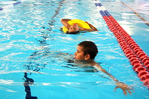 Child swimming with another child in the pool rescue tube