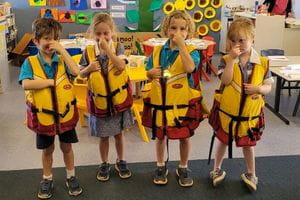 Children in a classroom wearing lifejackets