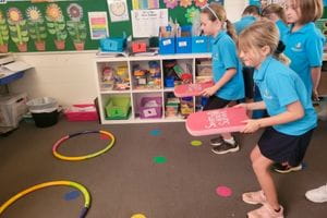 Children throwing kickboards into a hoop