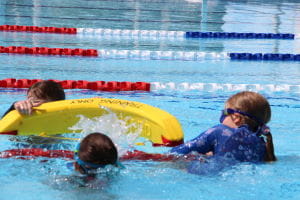 Children in the pool with rescue tube
