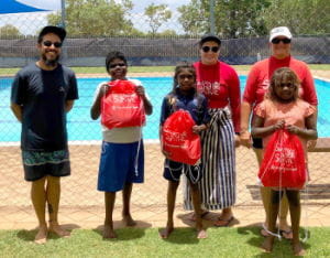 Students with their instructors holding their Swim and Survive packs