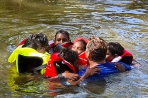 Students performing a HELP huddle in the river