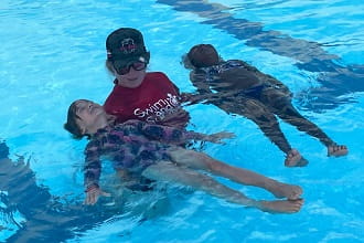 swim instructor with two young students
