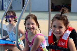 Three girls sitting along the edge of the pool at Geraldton Aquarena