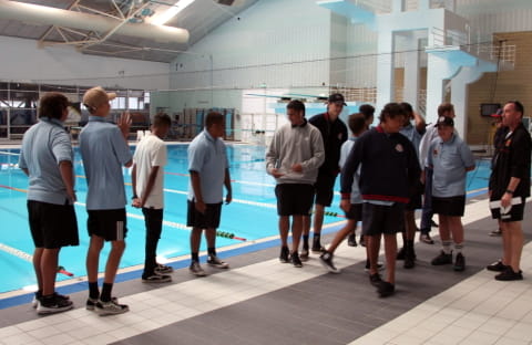 group of male high school students touring a public pool facility