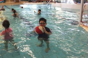 boy holding water polo ball in pool