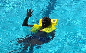 young aboriginal man wearing a lifejacket in a pool