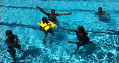 Aboriginal participants in the water while one wears a lifejacket