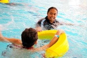 A Talent Pool staff member pulling a young boy in a rescue tube