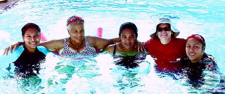 Multicultural women attending a swimming lesson at a pool