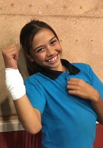 Baler Primary student holds up her bandaged forearm