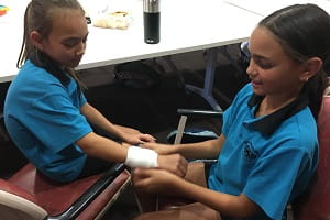 Girls from Baler Primary School at a first aid bandaging training session
