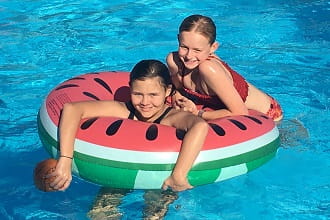 Two girls on a pool inflatable watermelon