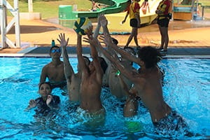 Youth playing volleyball in the pool