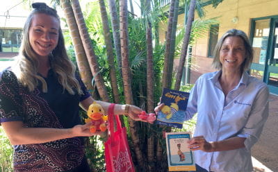 Two women holding Royal Life Saving ducks, books and activity bags