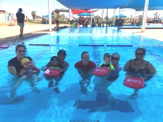 group of parents and toddlers enjoying an Infant Aquatics lesson with an instructor in the pool at Hedland