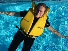 Woman wearing a lifejacket floating in the pool