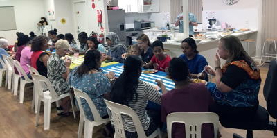 Women and their families enjoying a meal after completing their swimming lessons