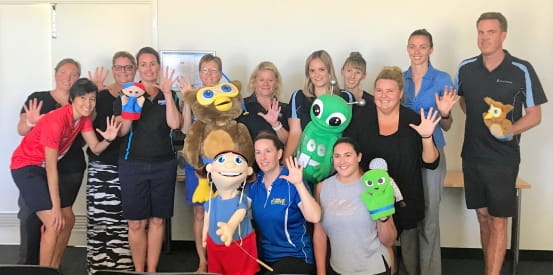 Swim instructors with Emma and Jane Lawrence and their Kids Alive mascots