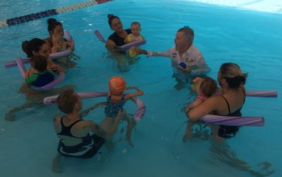 Laurie Lawrence in the water with mums and babies during an infant aquatics class