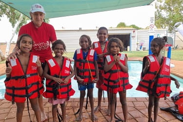 Jigalong children wearing PFDs as part of a swimming lesson