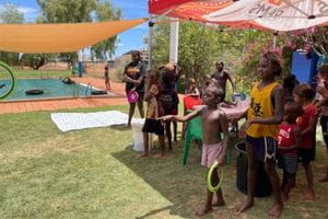 Children at Jigalong pool taking part in an activity on the grass