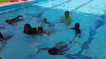 Aboriginal children enjoying swimming lessons at Jigalong Pool with Pool Manager David Lucas