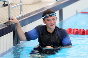 A boy in the pool with goggles on his head