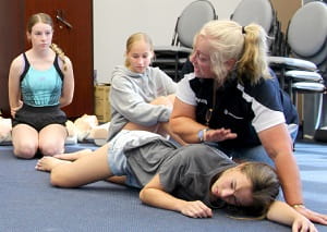 RLSSWA Trainer Gayle Cruden demonstrating recovery position with bronze medallion students