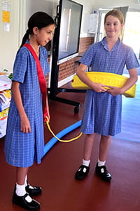 two primary school girls role-playing an aquatic rescue